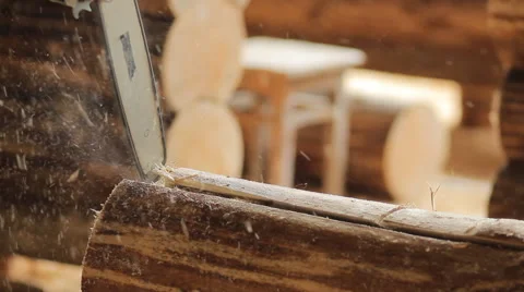 Man cuts off beam chainsaw for future home. Construction works with a wooden Stock Footage 65316976