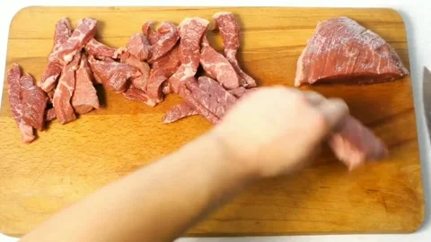 A man cuts beef on a cutting board in the kitchen Stock Footage 158836668