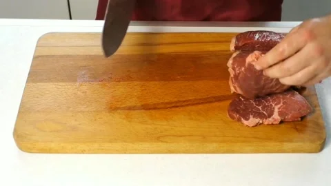 A man cuts beef on a cutting board in the kitchen Stock Footage 158836709
