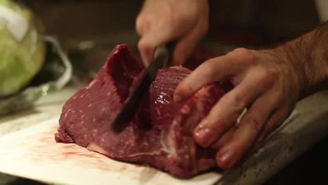 A man cuts beef Stock Footage 310692679
