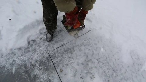 Man cuts blocks from ice with chainsaw Stock Footage 77280794