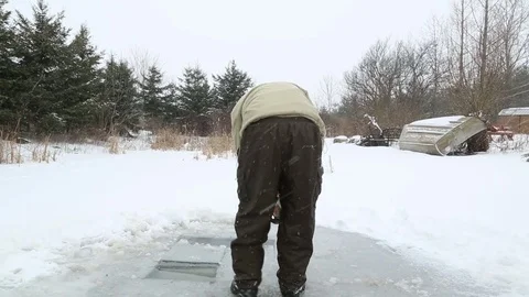 Man cuts blocks from ice with chainsaw wide Stock Footage 77281033