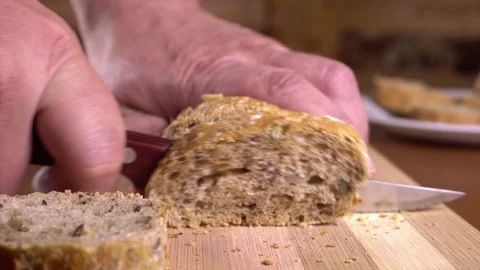 Man Cuts Bread in a close up shot Stock Footage 242355633
