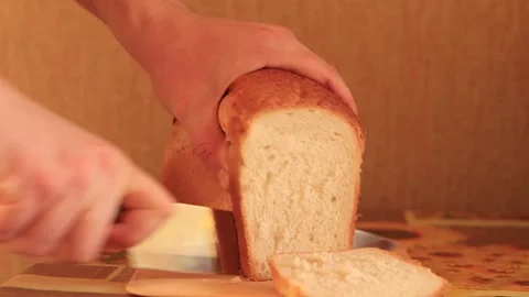 A man cuts bread with a knife Stock Footage 260005920