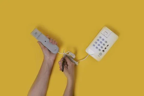 A man cuts a cable from the phone Stock Photos
