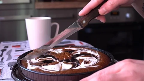 Man cuts a cake with a knife on the kitchen background Stock Footage 85992860