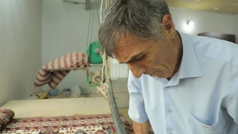 A man cuts a carpet with a special machine. Production of handmade carpets Stock Footage 121931376