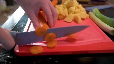 Man cuts carrot into small pieces with a knife Stock Footage 124678536