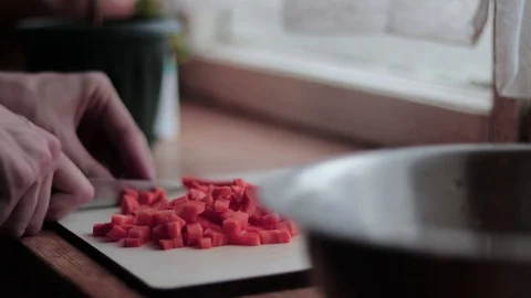 A man cuts carrots on a Board Video stock 129041736