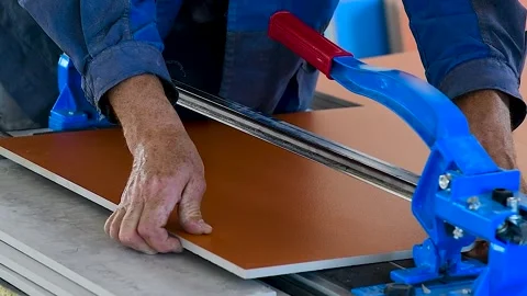 Man cuts ceramic tiles with a tile cutter. Stock Footage 321612477