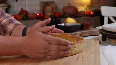 A man cuts into a cooked pumpkin pie with a knife Stock Footage 286117024