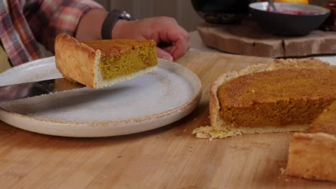 A man cuts into a cooked pumpkin pie with a knife 動画素材 286117528