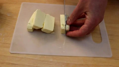 A man cuts into cubes butter that melts in his hands Stock Footage 155271696