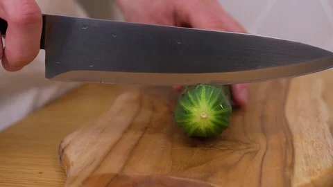 A man cuts a cucumber on a chopping Board Stock Footage 129056693