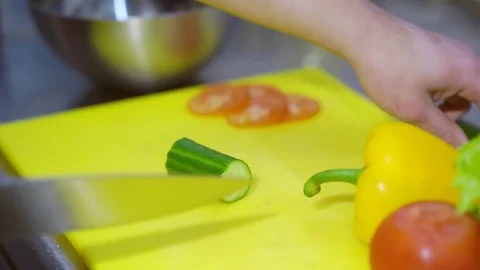 MAN cuts a cucumber with vegetables Video stock 73392829