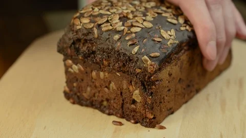 Man cuts dark bread with seeds Video stock 120685839