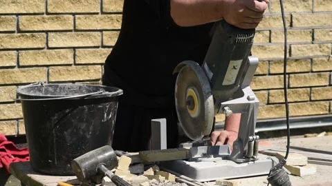 Man cuts a decorative brick with angle grinder on on a special stand Video stock 136431991