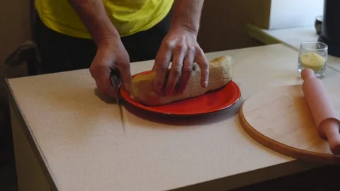 Man cuts the dough into equal pieces on a white table Stock Footage 86413505
