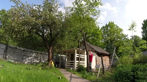 Man cuts down tree and clear land plot near village house Stock Footage 149416104