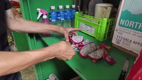 Man cuts dragon fruit or pitaya for sale, Fruit Market, Kowloon, Hong Kong Stock Footage 220507434
