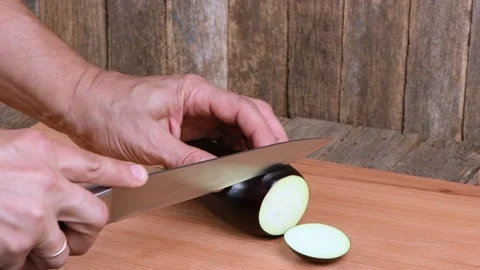The man cuts Eggplant. Side view. Stock Footage 163879046