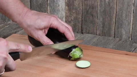 The man cuts Eggplant. Side view. Stock Footage 163879705