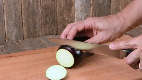 The man cuts Eggplant. Side view. Stock Footage 163880401