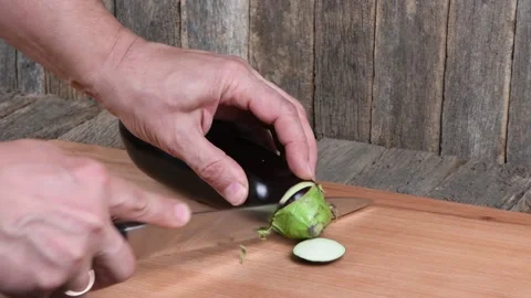 The man cuts Eggplant. Side view. Stock Footage 163880802