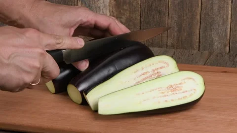 The man cuts Eggplant. Side view. Stock Footage 163883322