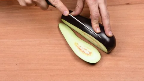 The man cuts Eggplant. Side view. Stock Footage 163895339