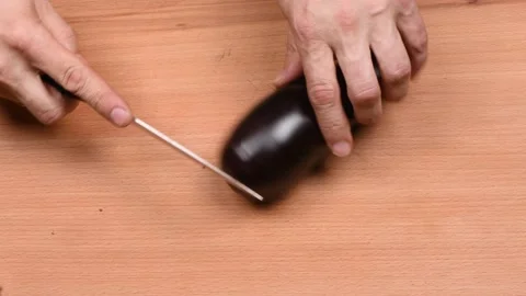 The man cuts Eggplant. Side view. Stock Footage 163895730