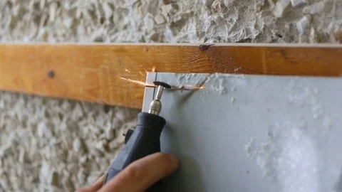 Man cuts off engraving machine tin drip mold. Indoors, side view, natural light, Stock Footage 83249118