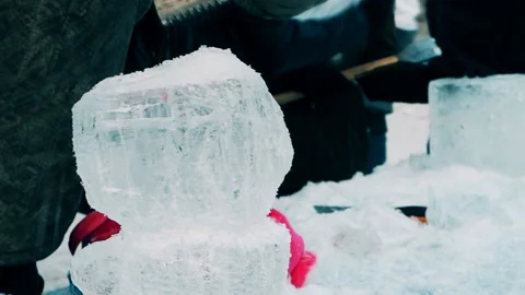 A man cuts a figure out of ice Stock Footage 104021150