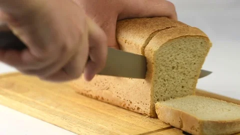 Man cuts fresh crisp bread of high quality with a knife Stock Footage 82526605