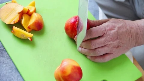 Man cuts up fresh nectarine Stock Footage 76091775