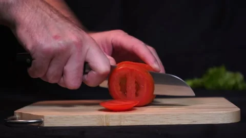 A man cuts fresh red tomatoes Stock Footage