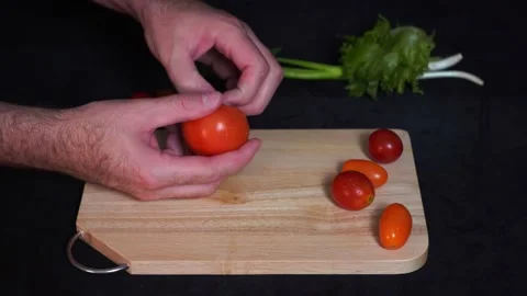 A man cuts fresh red tomatoes top view Stock Footage 162793064