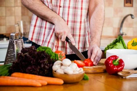 Man cuts fresh spring vegetables Foto stock
