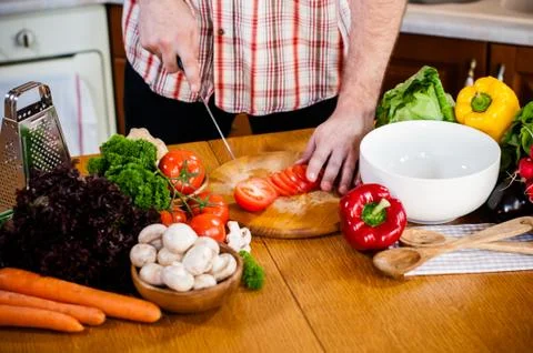 Man cuts fresh spring vegetables Foto stock