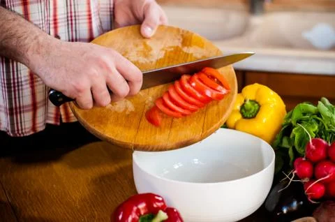 Man cuts fresh spring vegetables Foto stock