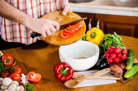 Man cuts fresh spring vegetables Foto stock