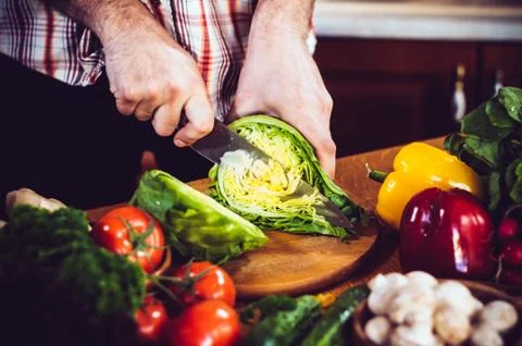 Man cuts fresh spring vegetables Foto stock