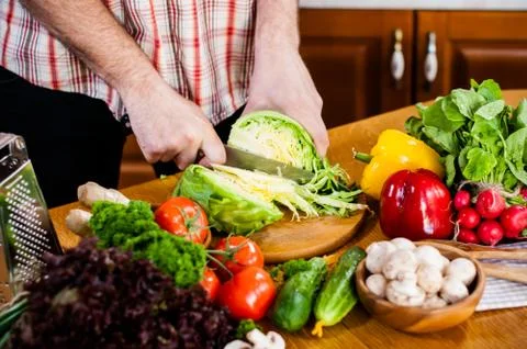 Man cuts fresh spring vegetables Foto stock