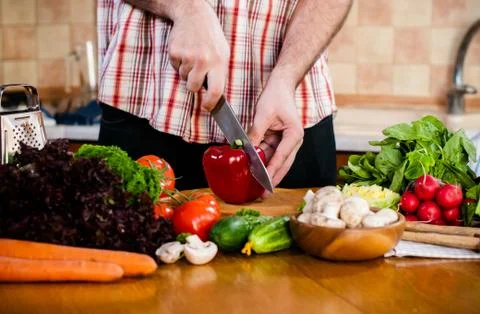 Man cuts fresh spring vegetables Foto stock