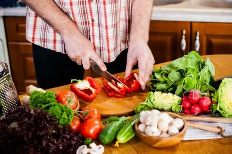 Man cuts fresh spring vegetables Foto stock