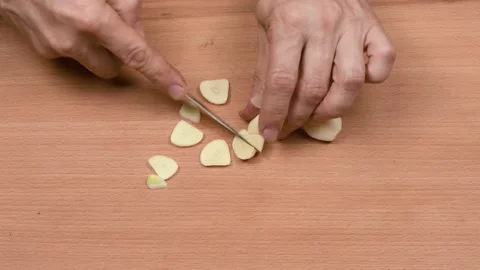 Man cuts garlic cloves. Side view. Stock Footage 163918660