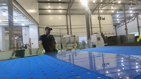 A man cuts the glass sheet on the table for overcutting. Stock-Footage 125483542