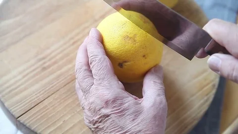 Man cuts grapefruit in half Stock Footage 76090379