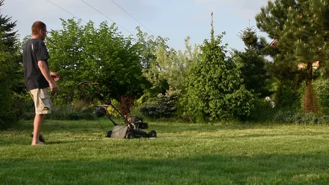 Man cuts grass in the garden 스톡 동영상 89402205