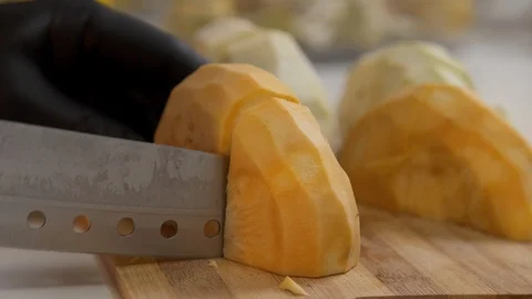 Man cuts half of turnip into large parts Stock Footage 121285655